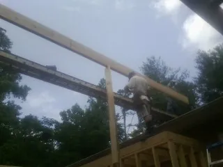 Carpenter setting a ridge beam over a new addition frame — Ice Dam Removal by Roofing Brothers in Wise River