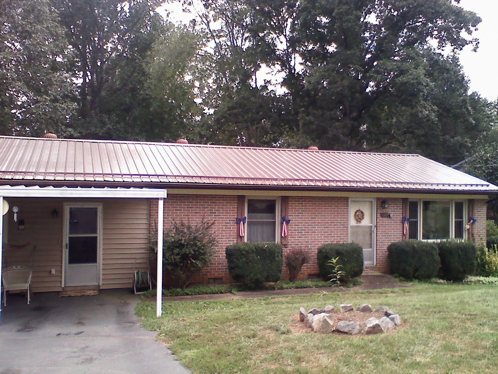 Bronze metal roof and carport on a brick ranch home — Roof Repair work by our crew in Wise River